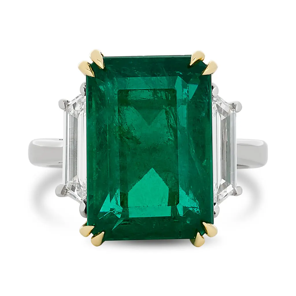 Three Stone Ring With An Emerald Cut Emerald Weighing 8.49ct And (2) Trapezoid Diamonds Weighing 0.62ct In Platinum and 18Kt Yellow Gold