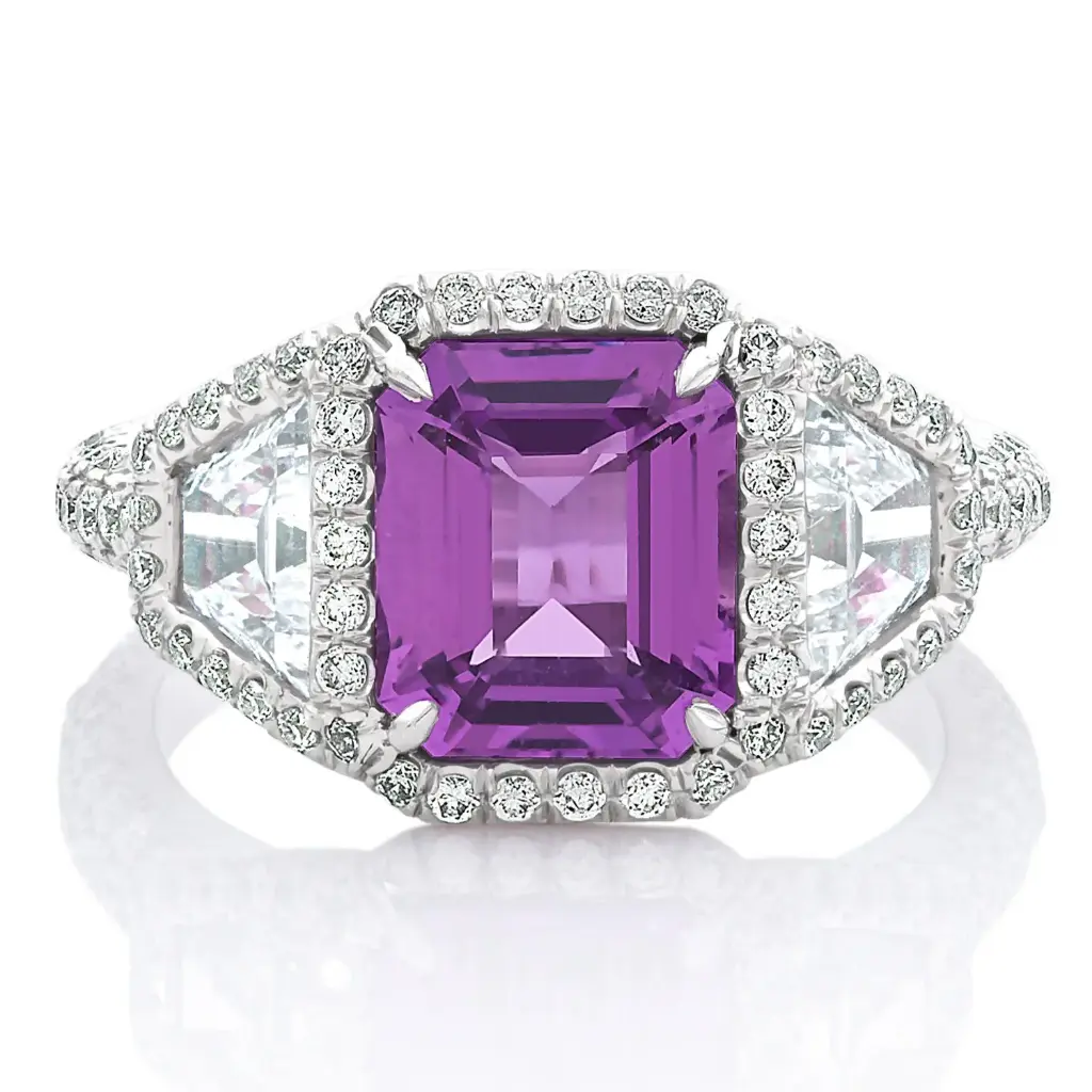 Three Stone Style Halo Ring With A Pink/Purple Sapphire Weighing 3.00ct, (2) Trapezoid Diamonds Weighing 1.30ct, And (118) Round Diamonds Weighing 1.00ct In Platinum