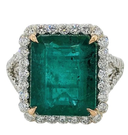 18Kt White Gold Halo Style Ring With An Octagonal Emerald Weighing 7.27ct And A Halo And Band Of 60 Round Diamonds Weighing 1.50ct
