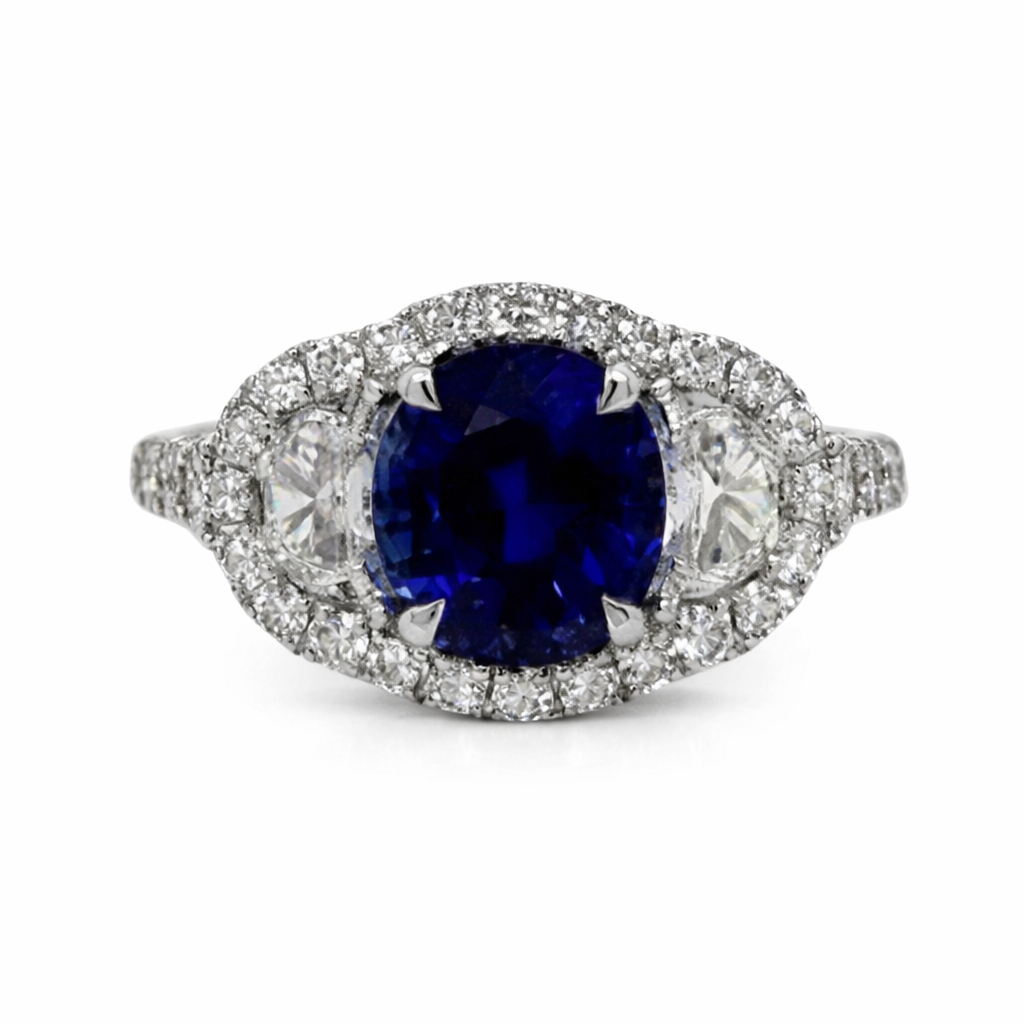 [22224] 18Kt White Gold Ring With A Cushion Cut Sapphire Weighing 2.46ct, (2) Half Moon Diamonds Weighing 0.47ct, And (36) Round Diamonds Weighing 0.55cttw