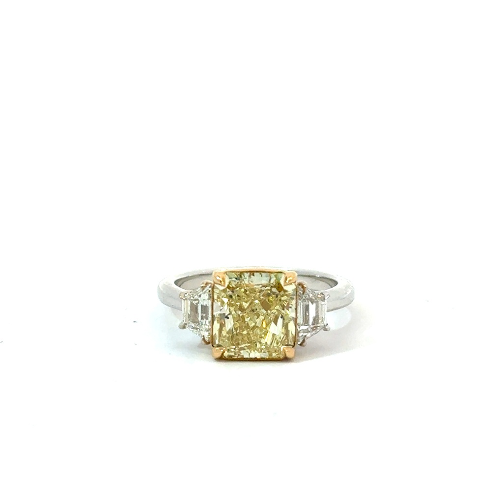 Three Stone Ring With a Radiant Yellow Diamond Weighing 3.42ct And (2) Trapezoid Diamonds Weighing 3.32ct In 18Kt White Gold