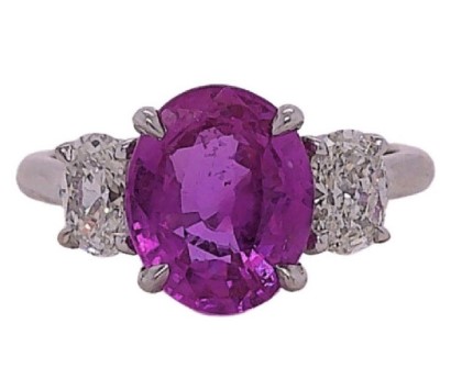 [20650] 18Kt White Gold Three Stone Ring With An Oval Pink Sapphire Weighing 3.32ct And (2) Oval Diamonds Weighing 0.77ct