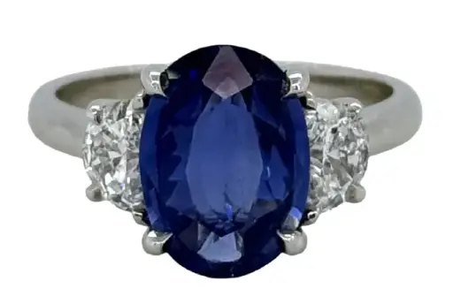 [23649] Platinum Three Stone Ring With An Oval Sapphire Weighing 3.35ct And (2) Half Moon Diamonds Weighing 0.64ct